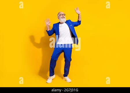 In voller Länge Körpergröße Foto des Mannes mit weißem Bart lachen tanzen überglücklich gelben Hintergrund Stockfoto