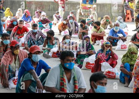 Dhaka, Bangladesch. Juli 2021. Menschen mit niedrigem Einkommen erhalten während der landesweiten Sperre zur Eindämmung der Ausbreitung des Coronavirus (COVID-19) in Dhaka, Bangladesch, 14. Juli 2021, Nahrungsmittel, die von der Armee von Bangladesch zur Verfügung gestellt werden. Quelle: Suvra Kanti das/ZUMA Wire/Alamy Live News Stockfoto