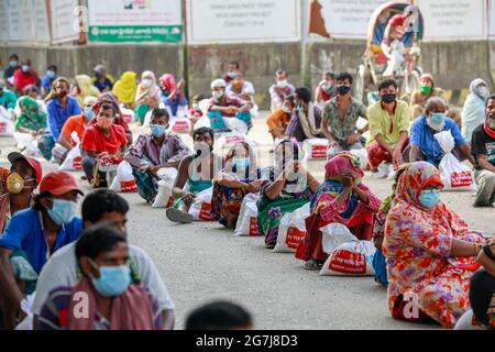 Dhaka, Bangladesch. Juli 2021. Menschen mit niedrigem Einkommen erhalten während der landesweiten Sperre zur Eindämmung der Ausbreitung des Coronavirus (COVID-19) in Dhaka, Bangladesch, 14. Juli 2021, Nahrungsmittel, die von der Armee von Bangladesch zur Verfügung gestellt werden. Quelle: Suvra Kanti das/ZUMA Wire/Alamy Live News Stockfoto