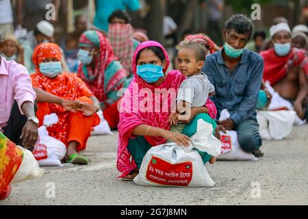 Dhaka, Bangladesch. Juli 2021. Menschen mit niedrigem Einkommen erhalten während der landesweiten Sperre zur Eindämmung der Ausbreitung des Coronavirus (COVID-19) in Dhaka, Bangladesch, 14. Juli 2021, Nahrungsmittel, die von der Armee von Bangladesch zur Verfügung gestellt werden. Quelle: Suvra Kanti das/ZUMA Wire/Alamy Live News Stockfoto