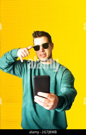 Der junge Mann winkte mit der Hand, während er einen Videoanruf auf der Straße machte Stockfoto