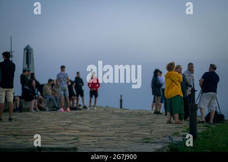 Junge Leute, Fotografen und ein Welpe auf einem Berggipfel erwarten den Sonnenaufgang - July Morning am 01. Juli 2021 Stockfoto