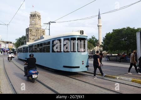 ANTALYA, TÜRKEI - 10. Jun 2021: Antalya, Türkei 10. Juni 2021 EINE nostalgische Straßenbahn, ein historischer Uhrenturm und Menschen auf der Straße in der Altstadt. Stockfoto