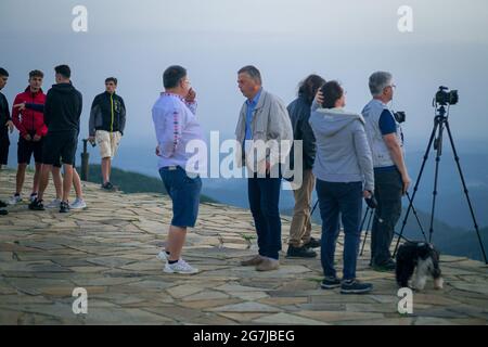 Junge Leute, Fotografen und ein Welpe auf einem Berggipfel erwarten den Sonnenaufgang - July Morning am 01. Juli 2021 Stockfoto