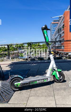 Limette Elektroroller auf Bürgersteig Stockfoto