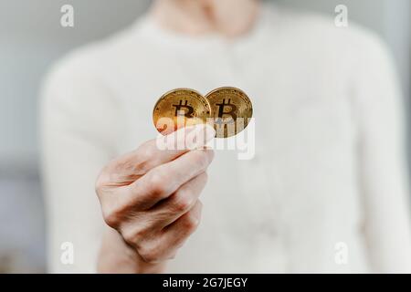 Bild von zwei Bitcoins in den Händen einer Frau. Stockfoto