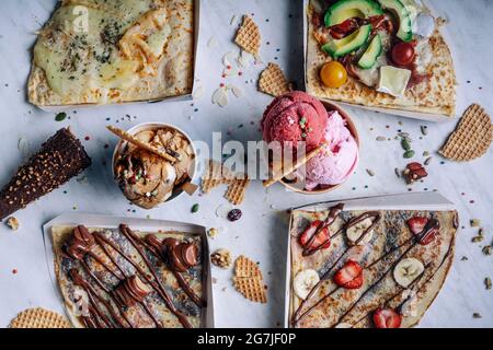 Luftaufnahme von verschiedenen Crepes und Eiscreme auf dem Tisch Stockfoto