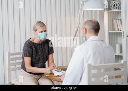 Arzt, der während des Besuchs mit dem Patienten spricht. Stockfoto