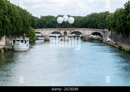 Rom, Italien. Juli 2021. 07/14/2021 Rom. Bis zum 18. Juli findet in Ponte Sisto die ephemere monumentale Installation 'Ponte Farnese' des französischen Künstlers Olivier Grossetête statt, die von der französischen Botschaft in Zusammenarbeit mit Webuild gefördert wird. Eine 18 Meter lange schwimmende Pappbrücke, die dank drei Luftballons über dem Tiber schwebt, erinnert an Michelangelos unvollendetes Projekt. Kredit: Unabhängige Fotoagentur/Alamy Live Nachrichten Stockfoto