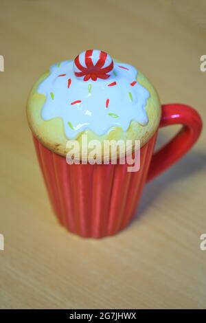 Roter Becher mit Deckel in Form eines Kuchens Stockfoto