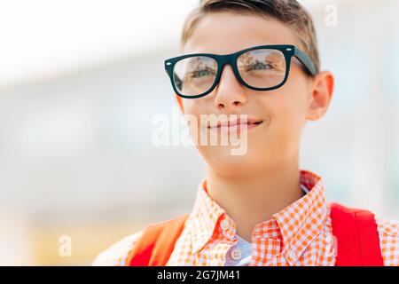 Portrait eines niedlichen Jungen in Brille, der mit seinem Schulrucksack zur Schule geht, Student Boy auf dem Weg zur Schule, Learning for children Stockfoto