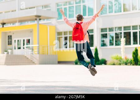 Glücklich lächelnder Junge mit Brille geht zur Schule, Junge mit Aktentasche geht in die Grundschule, Kind der Grundschule, Schüler geht mit einem zu studieren Stockfoto