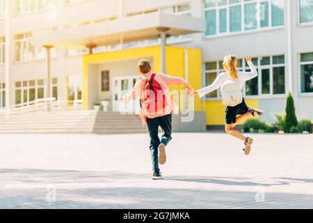 Schüler in Uniform Junge und Mädchen, die mit Schulrucksäcken zur Schule gehen, Schüler auf dem Weg zur Schule, für Kinder lernen Stockfoto