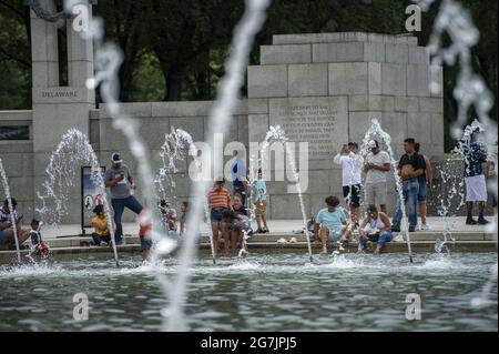 Washington, Usa. Juli 2021. Am Mittwoch, den 14. Juli 2021, versammeln sich am Zweiten Weltkrieg-Denkmal Menschen, um an einem heißen Tag in Washington, DC, im Wasser zu waten. Foto von Bonnie Cash/UPI Credit: UPI/Alamy Live News Stockfoto