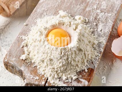 Mehl und Eigelb auf Holzbrett Stockfoto