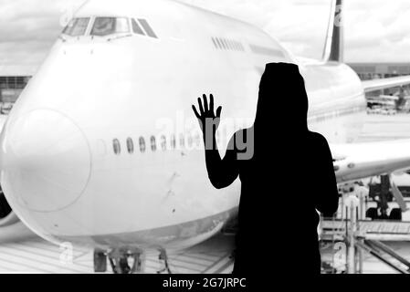 Schwarze Frau Silhouette Blick auf Flugzeuge in der Flughafenhalle - verpassten oder abgesagten Flug Konzept. Stockfoto