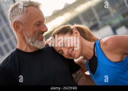 Porträt eines hübschen Paares mittleren Alters, eines Mannes und einer Frau in Sportkleidung, die an einem Sommertag in der Stadt ihr morgendliches Workout absolvieren Stockfoto