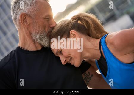 Porträt eines anhänglichen Paares mittleren Alters, eines Mannes und einer Frau in Sportkleidung, die an einem Sommertag in der Stadt ein morgendliches Workout absolvieren Stockfoto