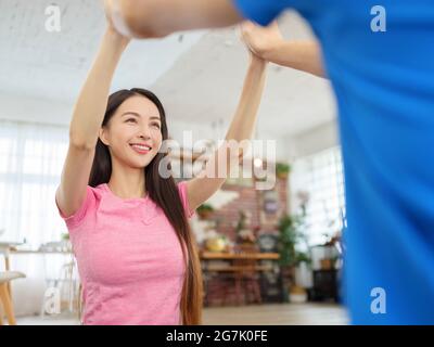 Mann und Frau im Sport tragen dabei Training im living room.Couple geben einander hohe fünf. Konzentrieren Sie sich auf Frau Gesicht. Stockfoto