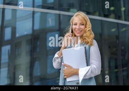 Geschäftsfrau, die in der Nähe des Business Centers telefoniert. Stockfoto