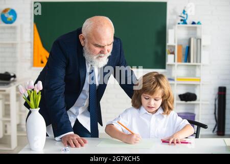 Reifer Großvater hilft Enkel mit Schulaufgabe, ältere Lehrer Ausbildung Schüler in der Lektion zu Hause, homeschooling Konzept. Stockfoto