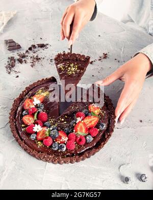 Junge Frau mit hausgemachtem Schokoladenherb auf hellgrauem Hintergrund. Stockfoto