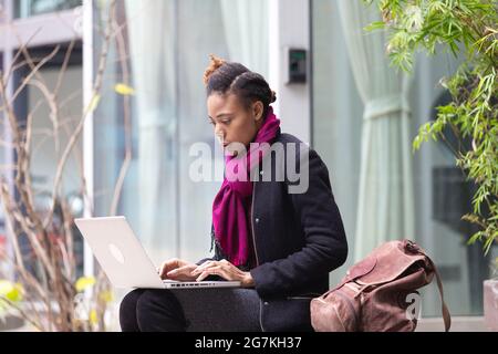 Schwarze Frauen, die auf der Straße mit Computern arbeiten Stockfoto