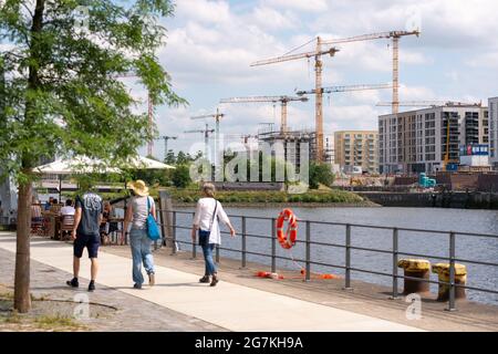 Hamburg, Deutschland. Juli 2021. Kinderwagen laufen am Baakenhafen über den Versmannkai, im Hintergrund sind Krane für den Hausbau zu sehen. Quelle: Jonas Walzberg/dpa/Alamy Live News Stockfoto