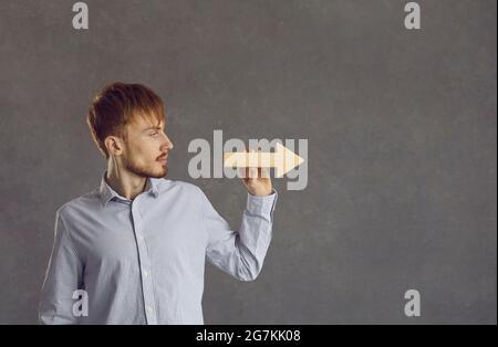 Selbstbewusster junger Geschäftsmann, Freiberufler, hält den Pfeil in die richtige Richtung Stockfoto