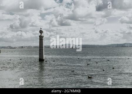 Graustufenaufnahme einer Steinsäule im Fluss Tejo in Portugal Stockfoto