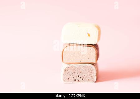 Verschiedene Schokoladen-Popsicles schneiden mit Füllung übereinander liegend. Rosa Hintergrund. Stockfoto