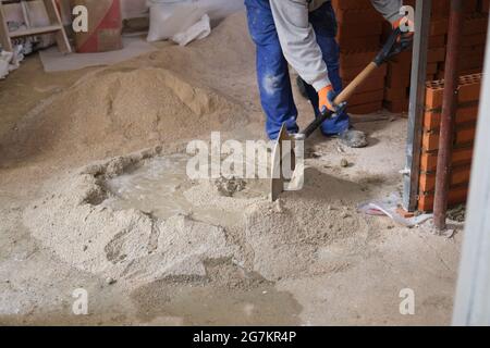 Bauarbeiter, der Zement vorbereitet. Maurer. Maurer Ziegeln. Stockfoto