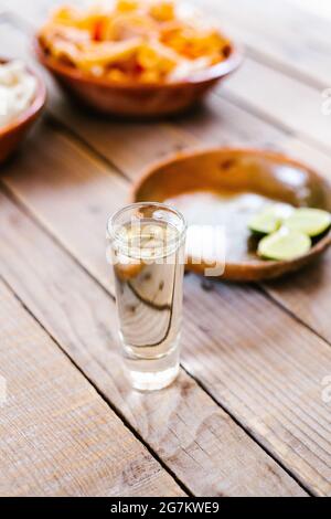 mexikanischer Tequila mit Kalk und Salz an einem rustikalen Tisch in Mexiko-Stadt Stockfoto