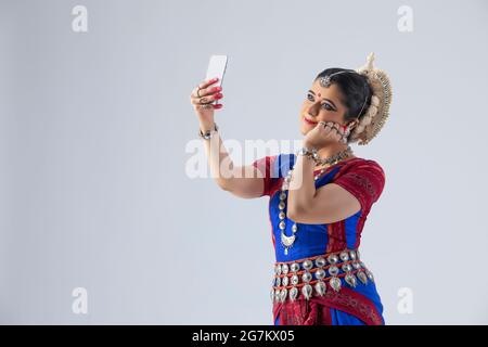 Odissi Tänzerin mit Mobiltelefon Stockfoto