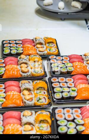 Japanisches Sushi-Essen. Maki und Brötchen mit Thunfisch, Lachs, Garnelen, Krabben und Avocado, verschiedene Sushi auf dem Markt in Tarragona Stockfoto