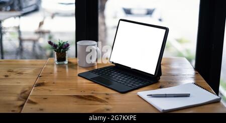 Nachbildung einer schwarzen Tafel mit weißem leeren Bildschirm auf einem Holzschreibtisch. Stockfoto