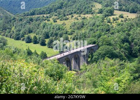 Radfahrer und Wanderer überqueren den Grabstein-Viadukt (Monsal Viaduct), einen Teil des Monsal Trail, von Monsal Head aus gesehen, in der Nähe von Bakewell, Derbyshire, England, Großbritannien Stockfoto