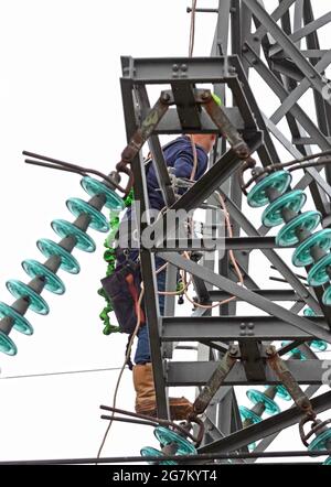 Elektriker arbeitet an einem Pol, Hochspannung Stockfoto