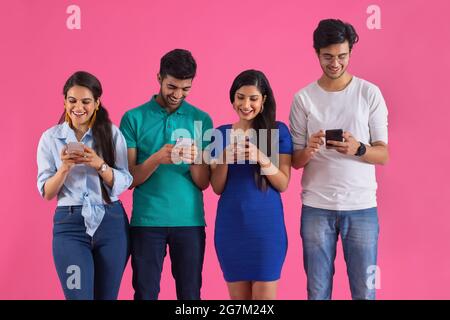 Eine Gruppe von Freunden hat sich auf unterschiedliche Weise mit ihrem Telefon beschäftigt. Stockfoto