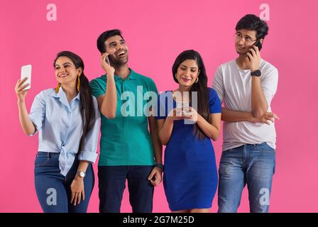 Eine Gruppe von Freunden hat sich auf unterschiedliche Weise mit ihrem Telefon beschäftigt. Stockfoto