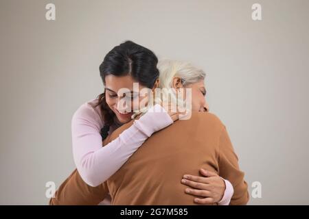 PORTRÄT EINER JUNGEN FRAU, DIE EINE ÄLTERE FRAU UMARMT PORTRÄT EINER JUNGEN FRAU, DIE EINE ÄLTERE FRAU UMARMT Stockfoto
