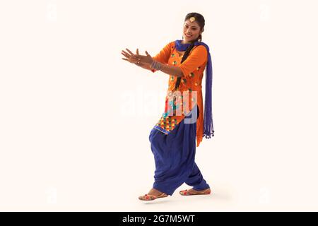 Giddha-Tänzerin, die einen Tanzschritt mit Handgesten ausführt. Stockfoto