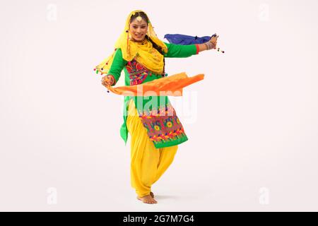 Eine Giddha-Tänzerin, die einen Tanzschritt mit farbenfrohem Tuch vorführt. Stockfoto