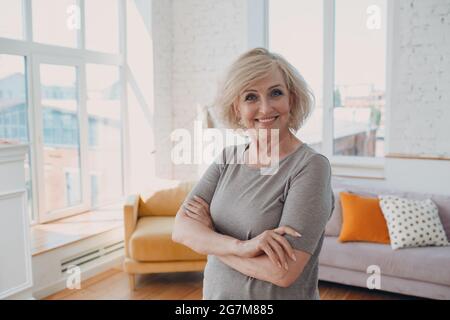 Ältere kaukasische alte Frau Porträt grauhaarig positiv lächelnd stehen Stockfoto