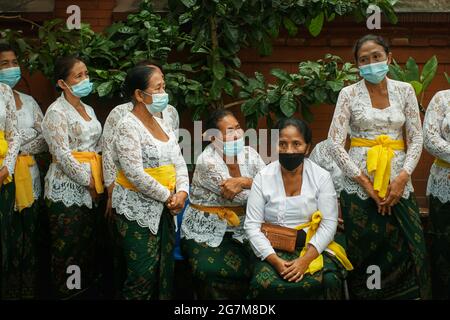 UBUD, BALI-MAI 11 2021: Balinesische Frauen in traditionellen balinesischen Kleidern wie Kebayas und Sarongs treffen sich zu einer hinduistischen Zeremonie. Sie tragen Stockfoto