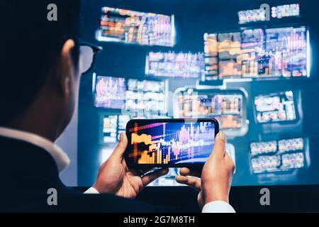 Business man mit Handy-App-Analyse für den Handel mit Finanzmarktgraphen. Stockfoto