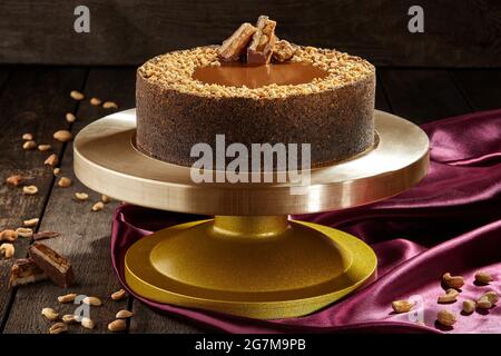 Käsekuchen mit gesalzenem Karamell, Erdnüssen und Schokoladenriegel Stockfoto