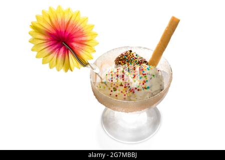 Drei Eiskugeln mit Schokolade, Creme und Vanille-Geschmack mit Zuckerperlen, Waffel und Papierblume in Glasbecher, isoliert auf Weiß Stockfoto