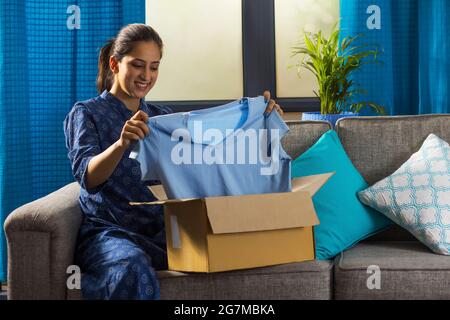 Eine Frau, die sich ihren neu bestellten Stoff ansieht. Stockfoto