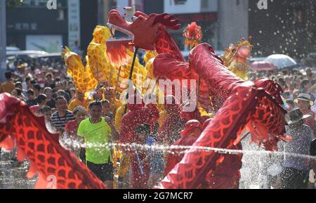 Jianhe, Chinas Provinz Guizhou. Juli 2021. Ein Drachentanz-Team tritt inmitten von Wasserspritzern auf, um das ethnische Fest „Liuyueliu“ im Bezirk Jianhe in der autonomen Präfektur Qiandongnan Miao und Dong, südwestlich der Provinz Guizhou, zu feiern, 15. Juli 2021. Quelle: Yang Ying/Xinhua/Alamy Live News Stockfoto